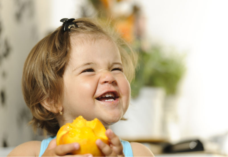 girl with nectarine laughing